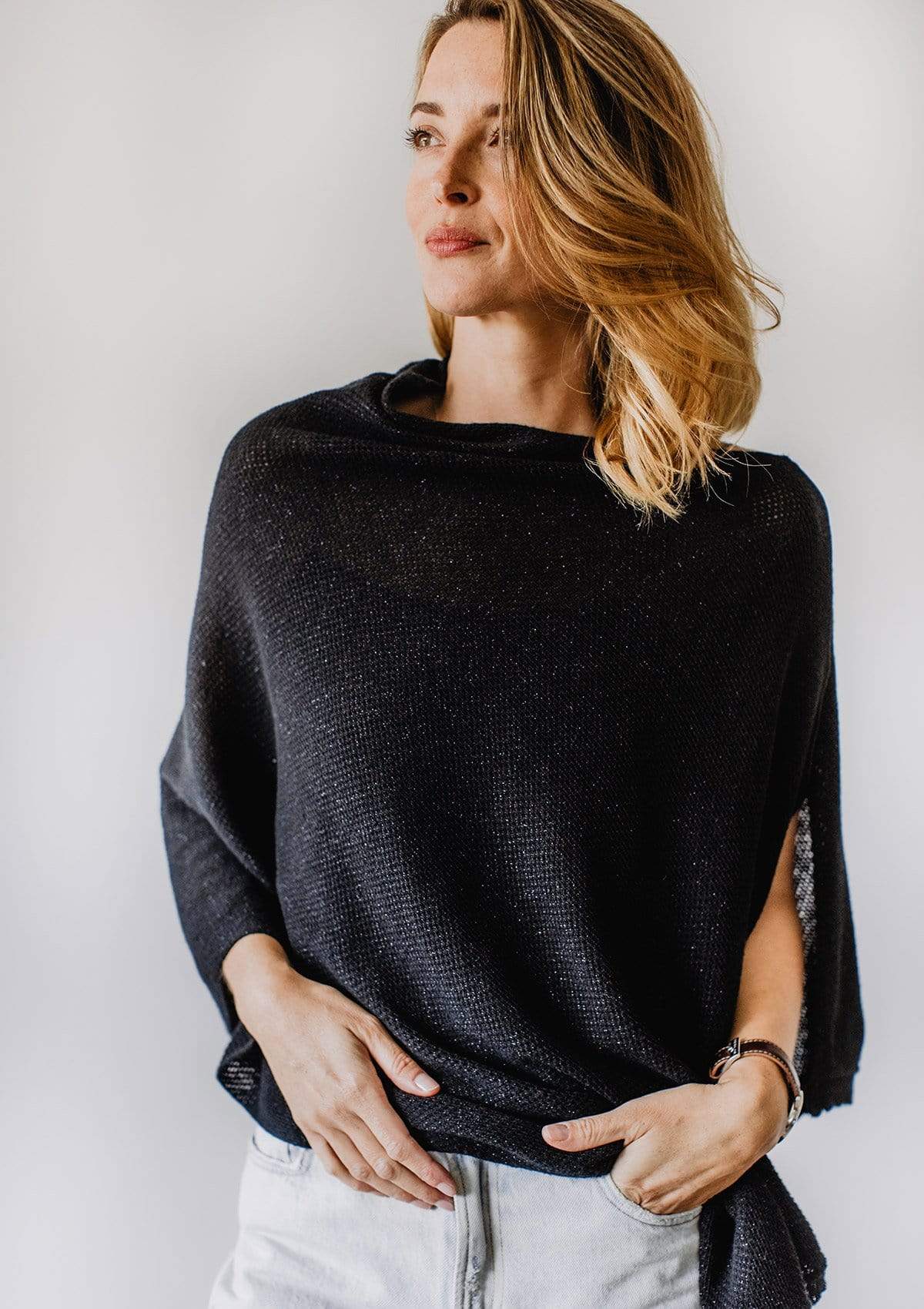 Emily Baldoni wearing sparkly black knit nursing poncho