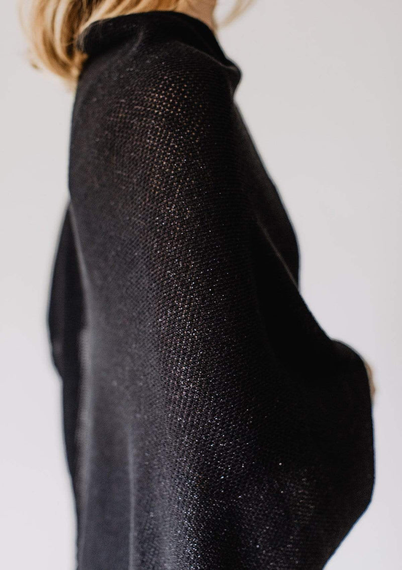 Closeup side view of sparkly black knit nursing cover on Emily Baldoni