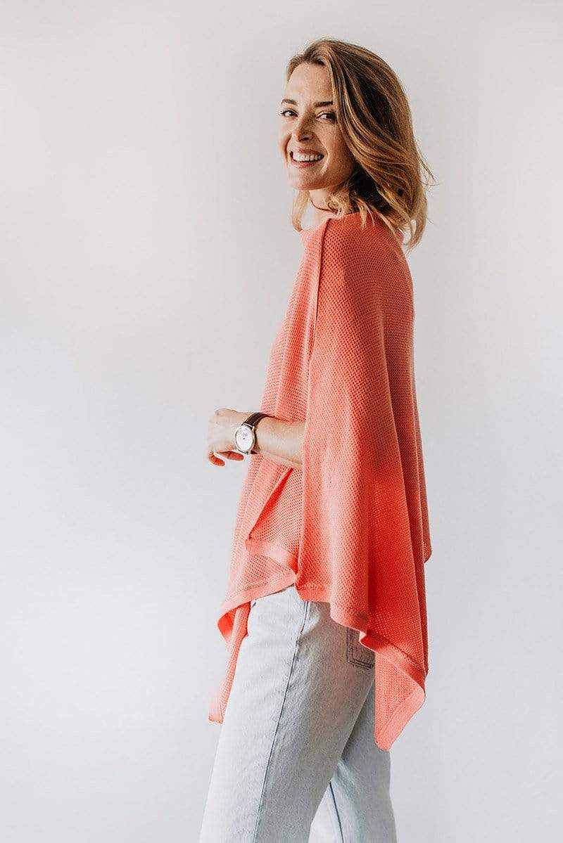 Side view of Emily Baldoni wearing coral knit Cocoon nursing poncho