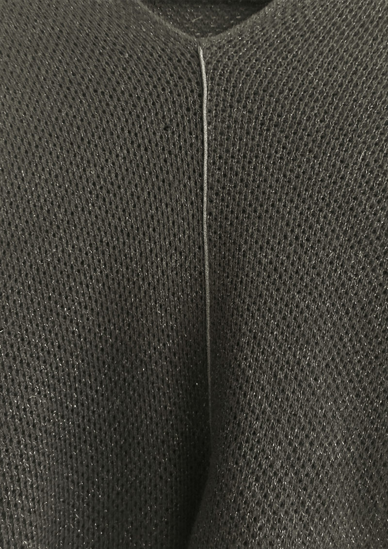 Closeup of a black knit nursing cover showing breathable texture of knit and metallic black piping